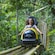 A woman strapped onto a bobsled ride amid a natural landscape and the words ‘Mystic Mountain’